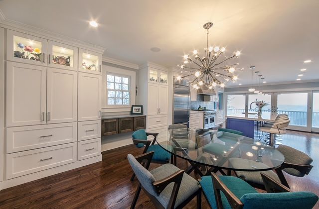 A dining room with a glass table and chairs and a chandelier.