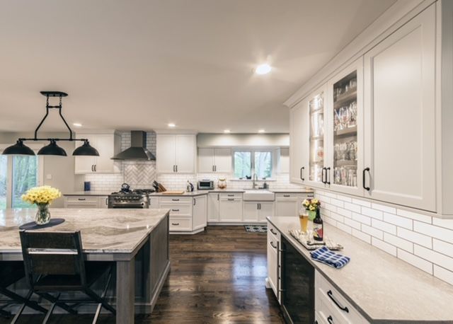 A kitchen with white cabinets and a large island in the middle.