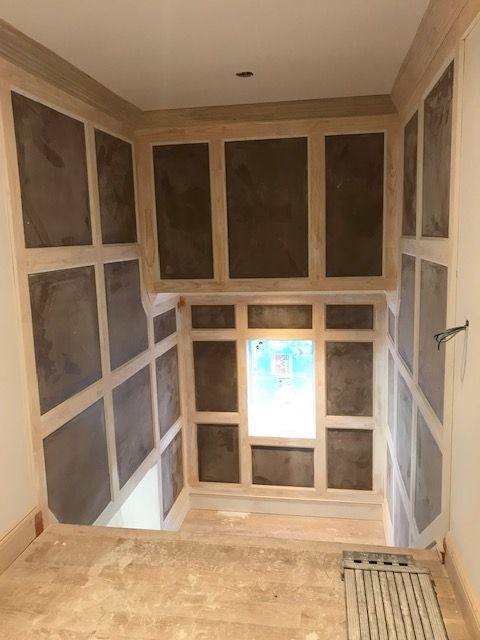 A room with a lot of squares on the wall and a window.