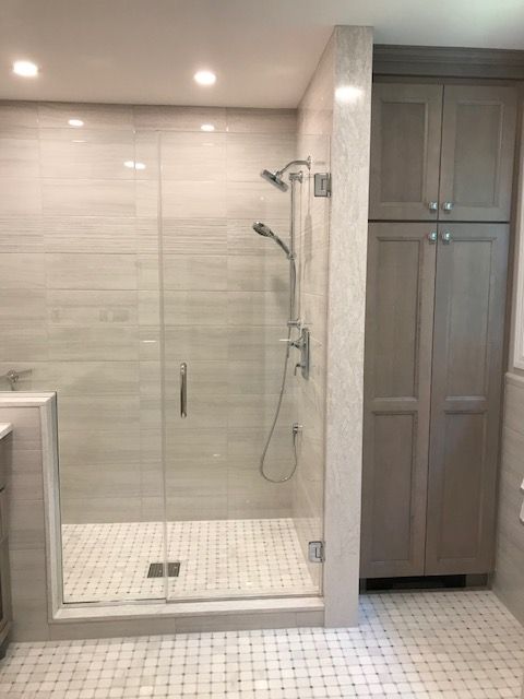 A bathroom with a walk in shower and a sink.