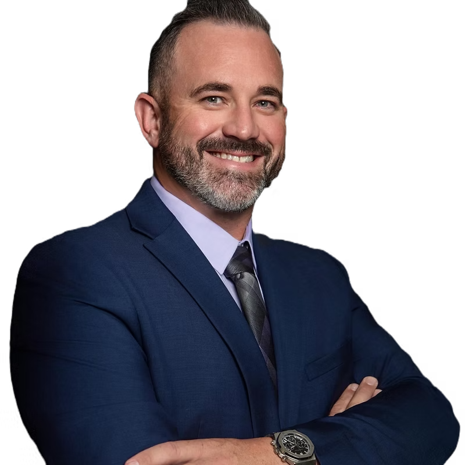 A man in a suit and tie is smiling with his arms crossed