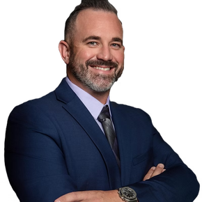 A man in a suit and tie is smiling with his arms crossed