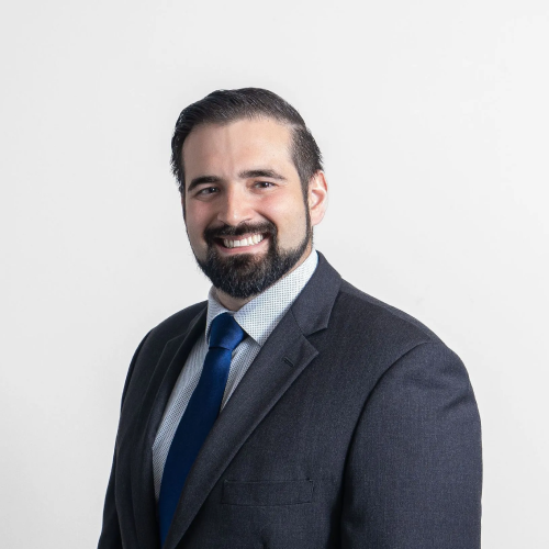 A man in a suit and tie is smiling for the camera.