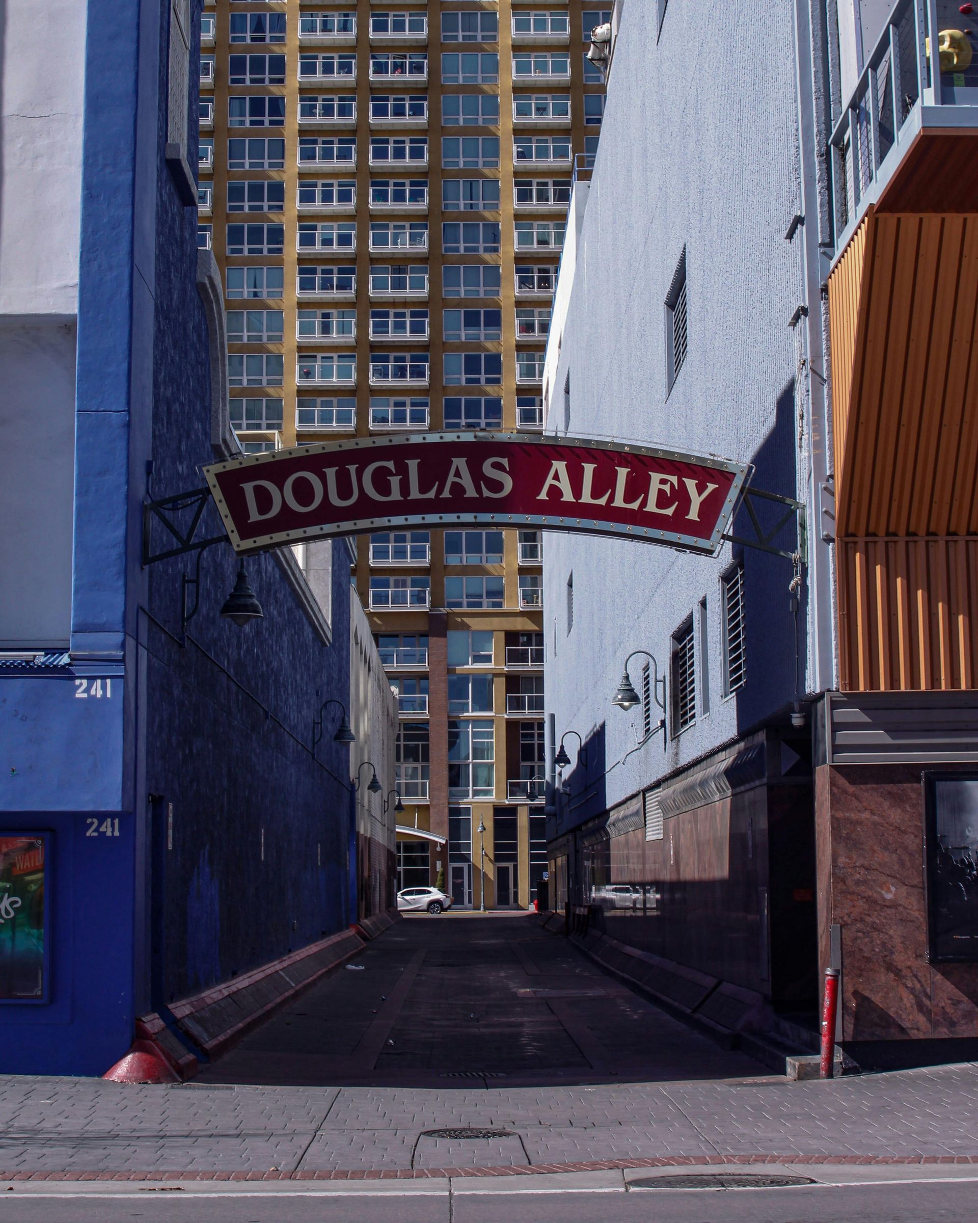 A narrow alleyway with a sign that says douglas alley