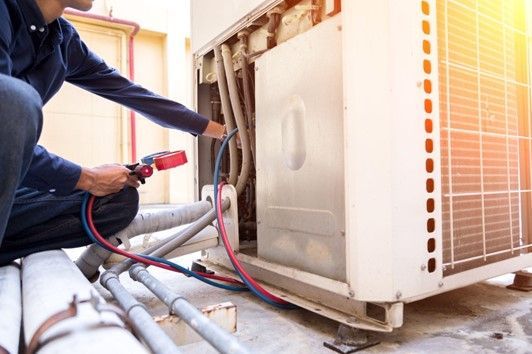 Picture Of Man Fixing Air Conditioner — Gulf Coast, MS — C. J. Services, Inc.