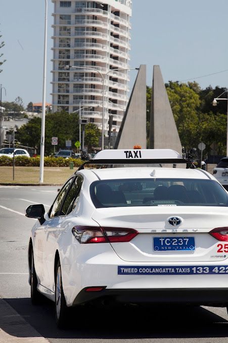 A White Taxi is Parked on the Side of the Road — Tweed Heads Coolangatta Taxi Service In Banora Point, NSW