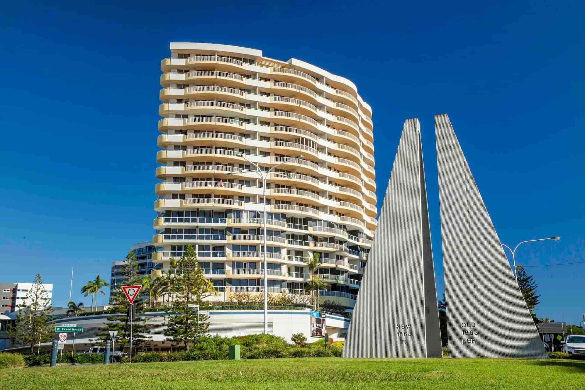 A Tall Building With a Sculpture in Front of It — Tweed Heads Coolangatta Taxi Service In Tweed Heads, NSW