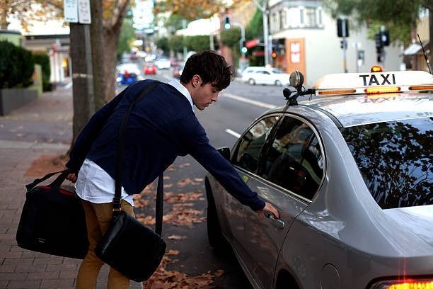 A Man is Getting Into a Taxi on the Side of the Road — Tweed Heads Coolangatta Taxi Service In Tweed Heads, NSW