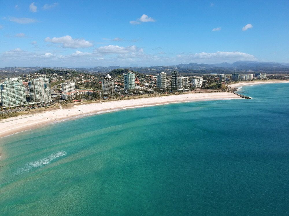 An Aerial View of a Beach With a City in the Background — Tweed Heads Coolangatta Taxi Service In Kirra, QLD
