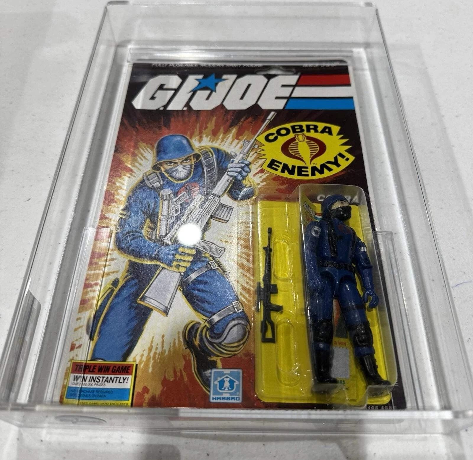 A vintage G.I. Joe action figure in a plastic case, the card art featuring a blue-clad soldier.