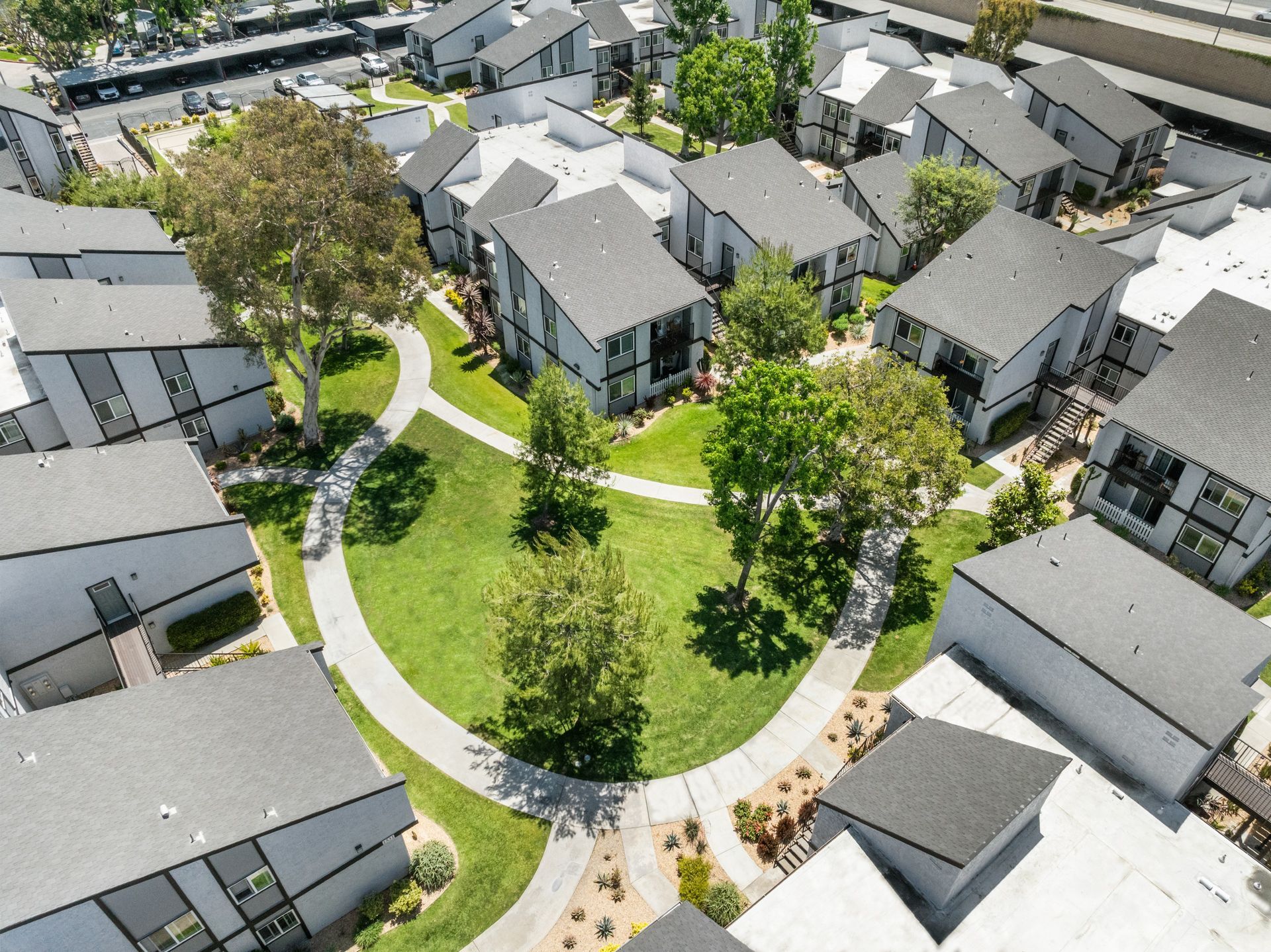 overhead view of apartments, grass field, and trees