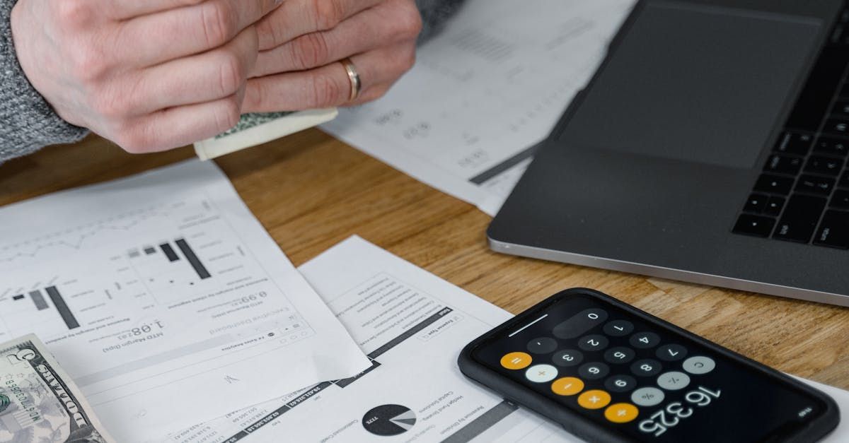 A person is sitting at a table with a laptop and a calculator.