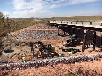 workers place rocks - commercial construction in WY