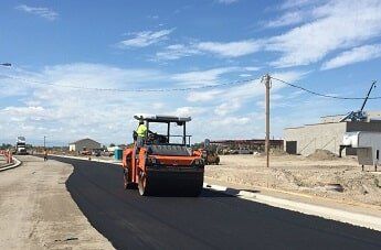 steam roller flattens asphalt - road construction in WY