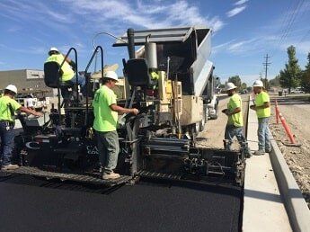 construction workers ride asphalt machine - road construction in WY