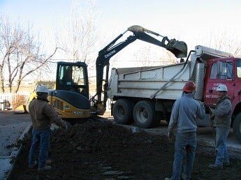 tractor loading dirt in dump truck - commercial construction in WY