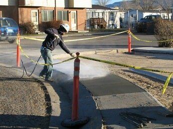 man sprays concrete road - commercial construction in WY