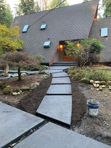 A modern home with a wavy roof and a slate path leading to the front door.
