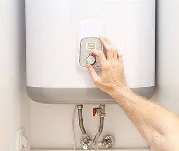 Man Setting Water Heater Temperature — Bartlesville, OK  — C & M Plumbing