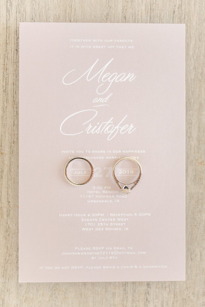 Wedding invitation on pink background with rings.