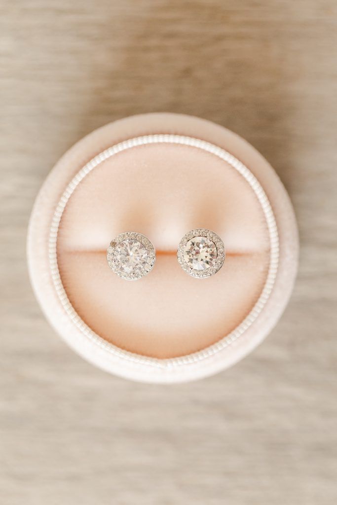 Diamond stud earrings in a pink velvet jewelry box.