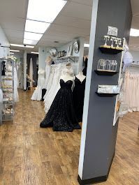 Inside a bridal shop, dresses on mannequins, including a black beaded gown.