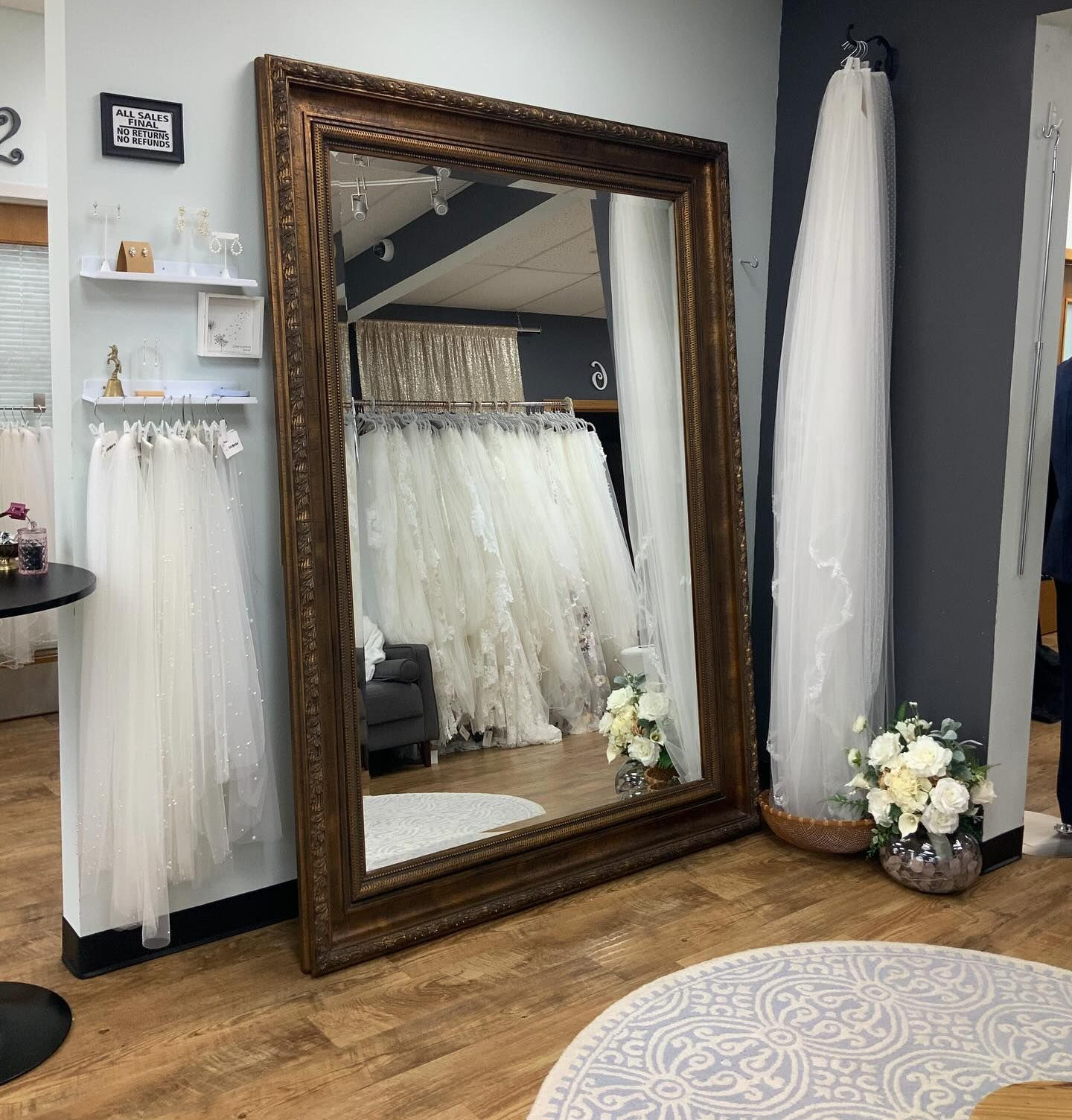 Inside a bridal shop, dresses on mannequins, including a black beaded gown.