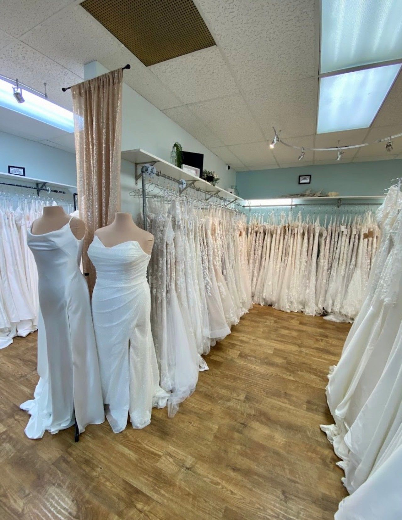 Wedding dresses displayed in a bridal shop, in various white and cream colors.