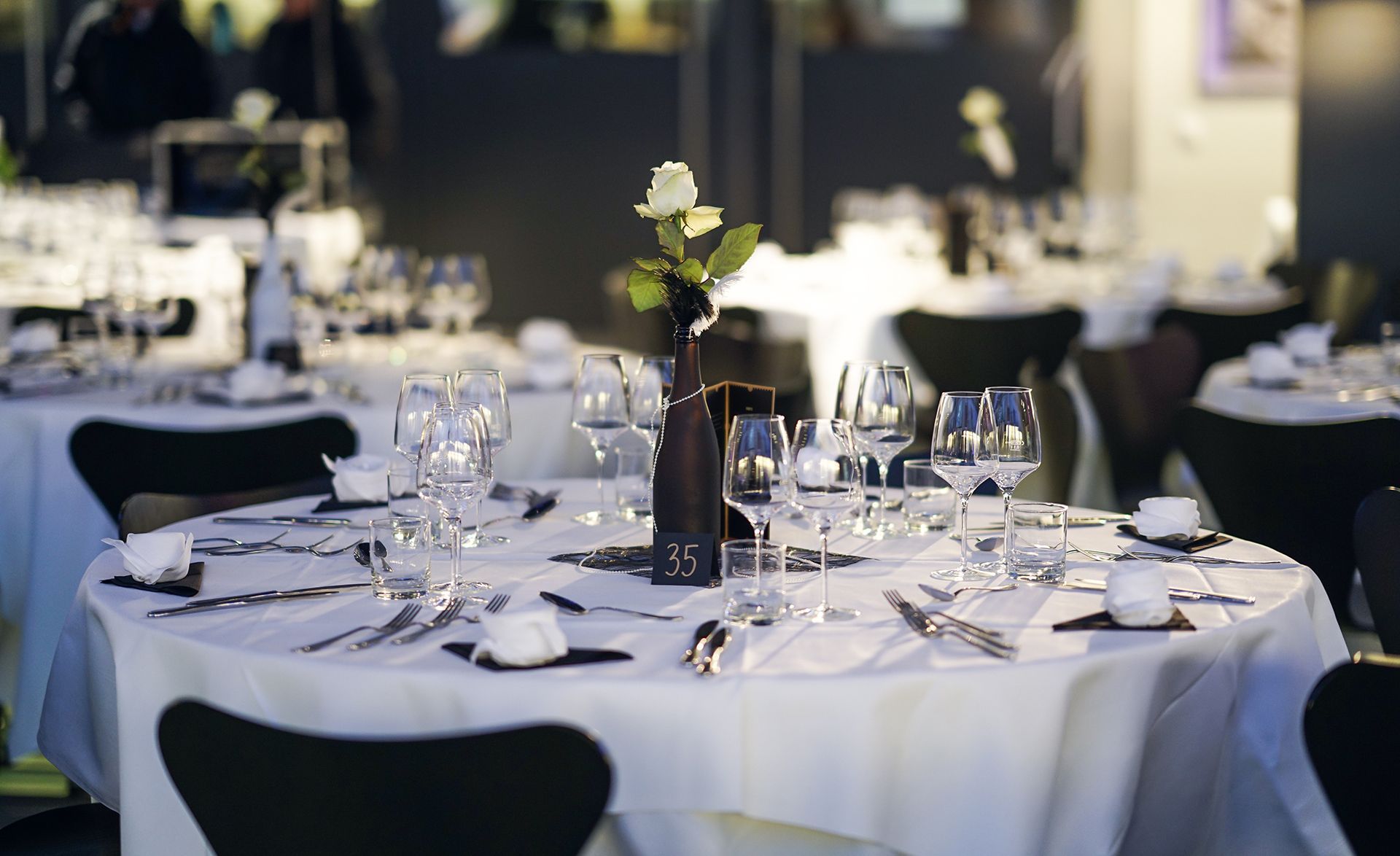 A table set for a dinner party with a vase of flowers on it.