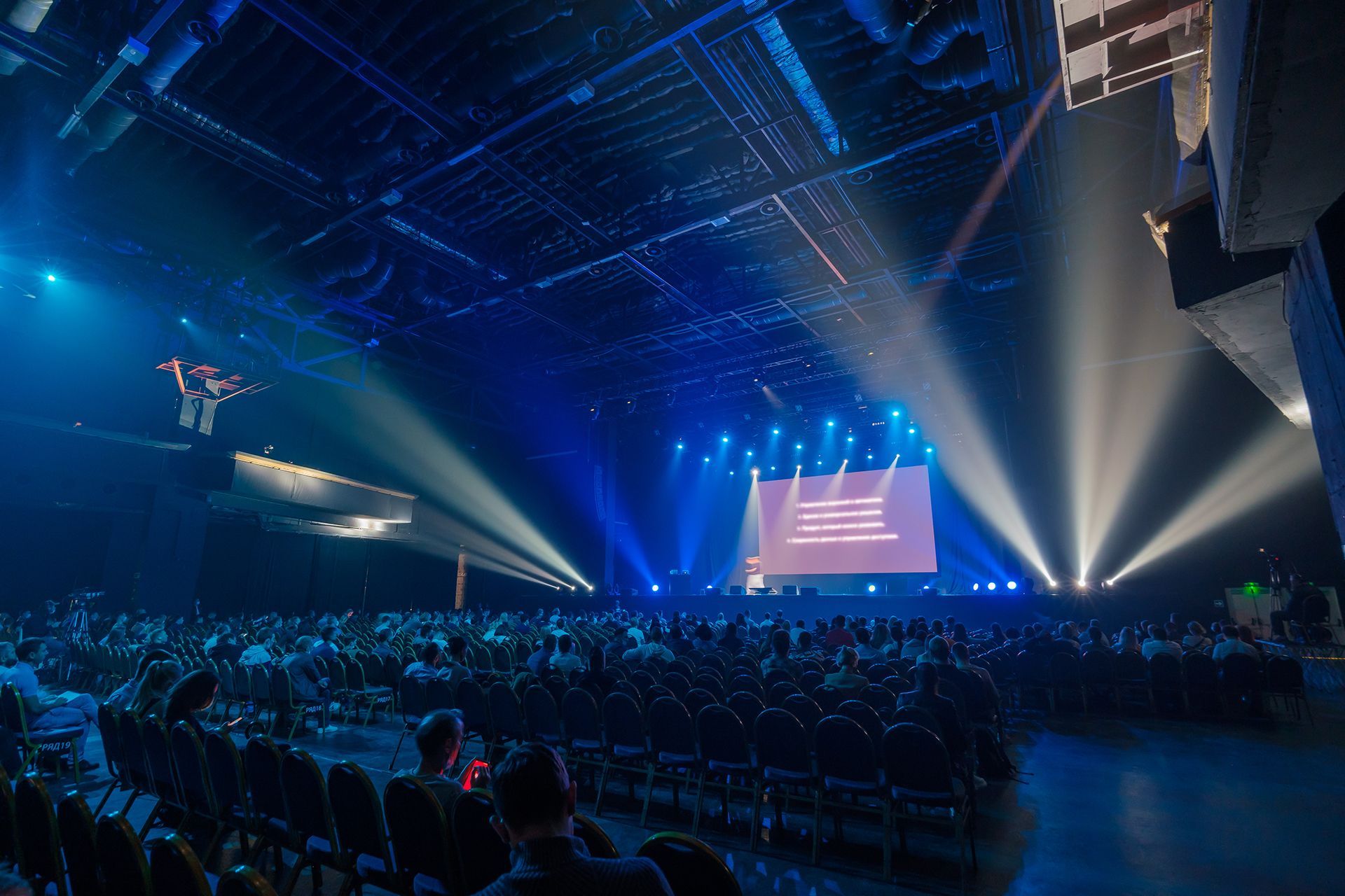 A large crowd of people are sitting in a stadium watching a concert.