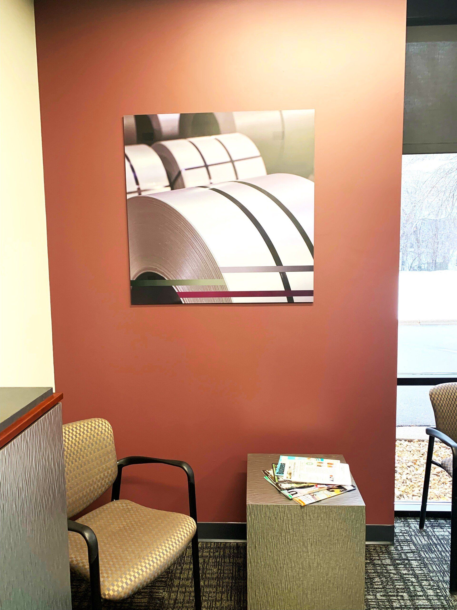 A waiting room with chairs and a painting on the wall