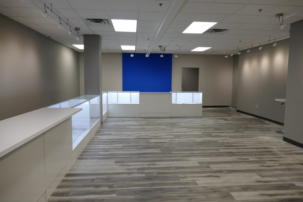 A large empty room with a blue wall in the middle