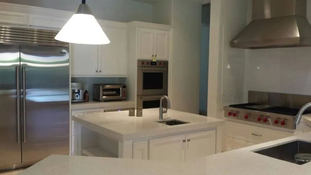 A kitchen with stainless steel appliances and white cabinets