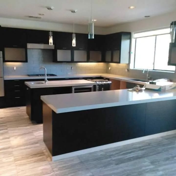 A kitchen with black cabinets and white counter tops