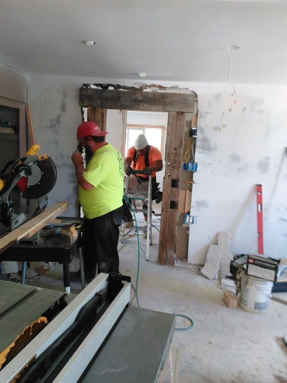 A man in a yellow shirt is working on a table saw