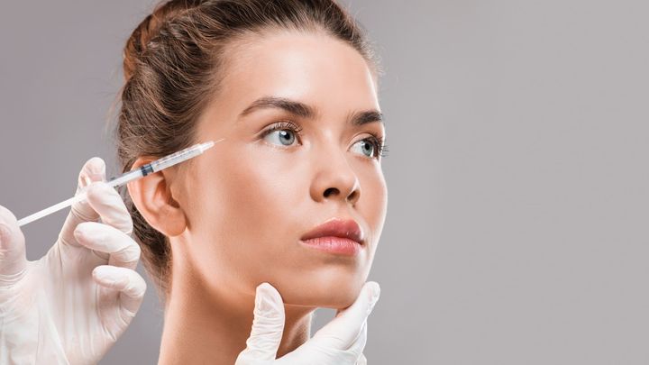 A woman getting Botox injections near her eyes.
