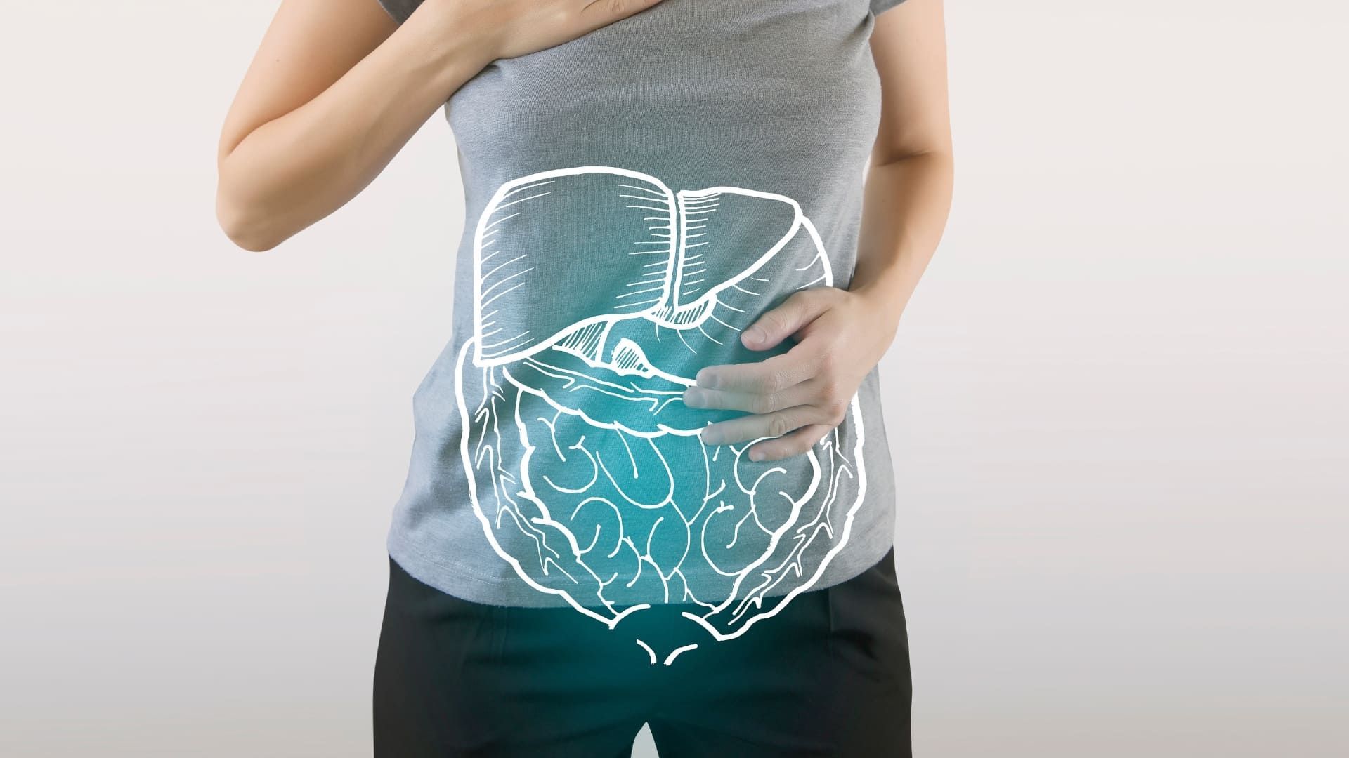 A person holding their stomach with a drawing of their digestive system on it.