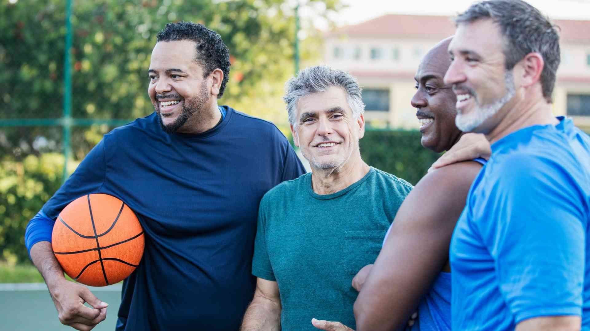 A group of older men playing basketball.