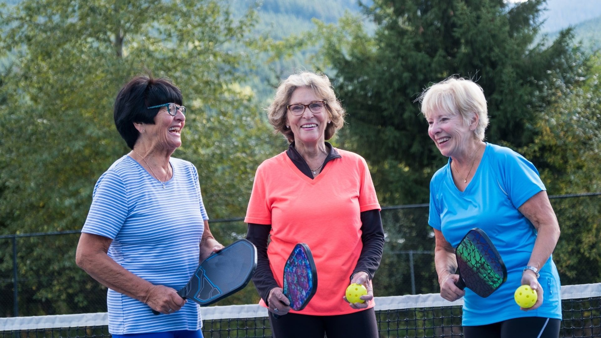 A group of older women playing pickleball.