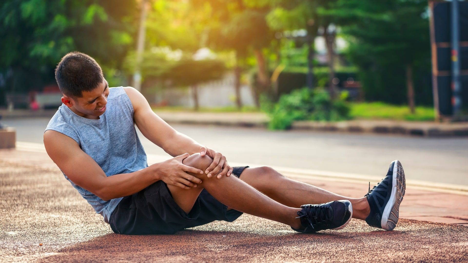 A young man is on the ground after injurying his knee.