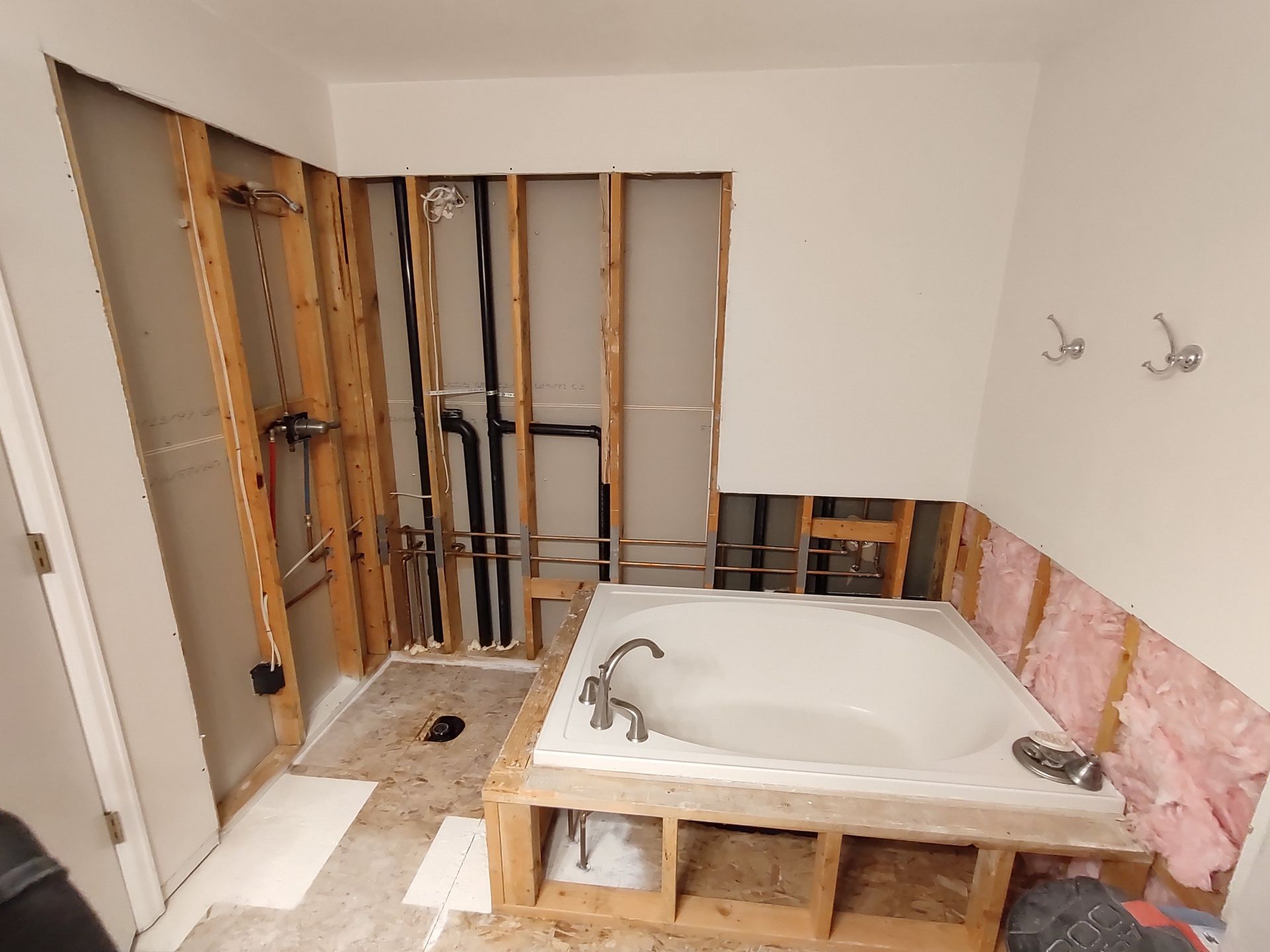 A bathtub is sitting in a bathroom under construction.