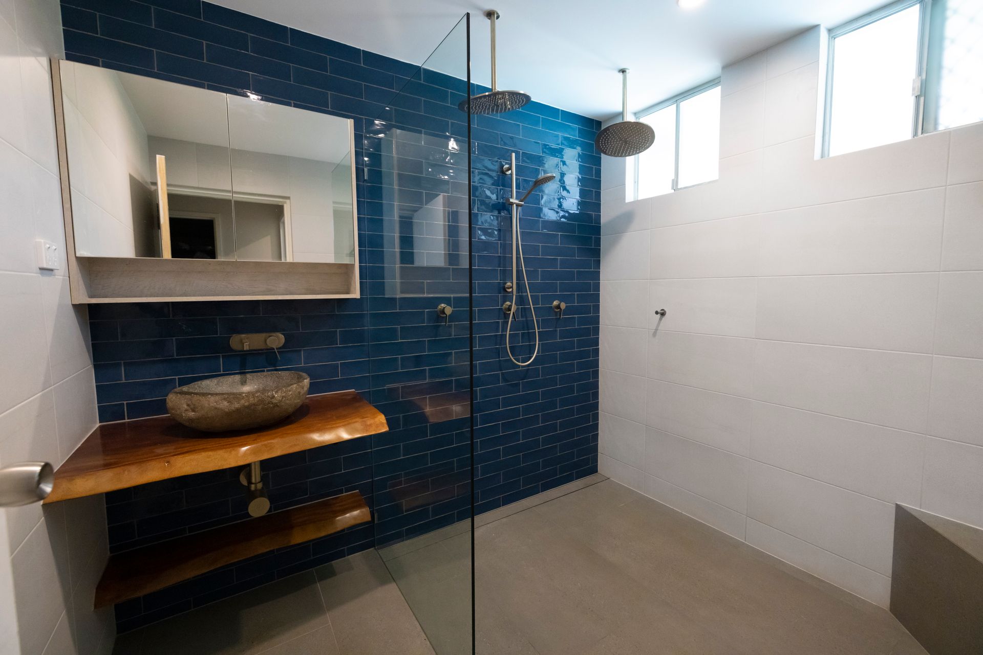 A Person is Installing Tiles on a Wall — Anderson Tiling and Waterproofing in Whitfield, QLD