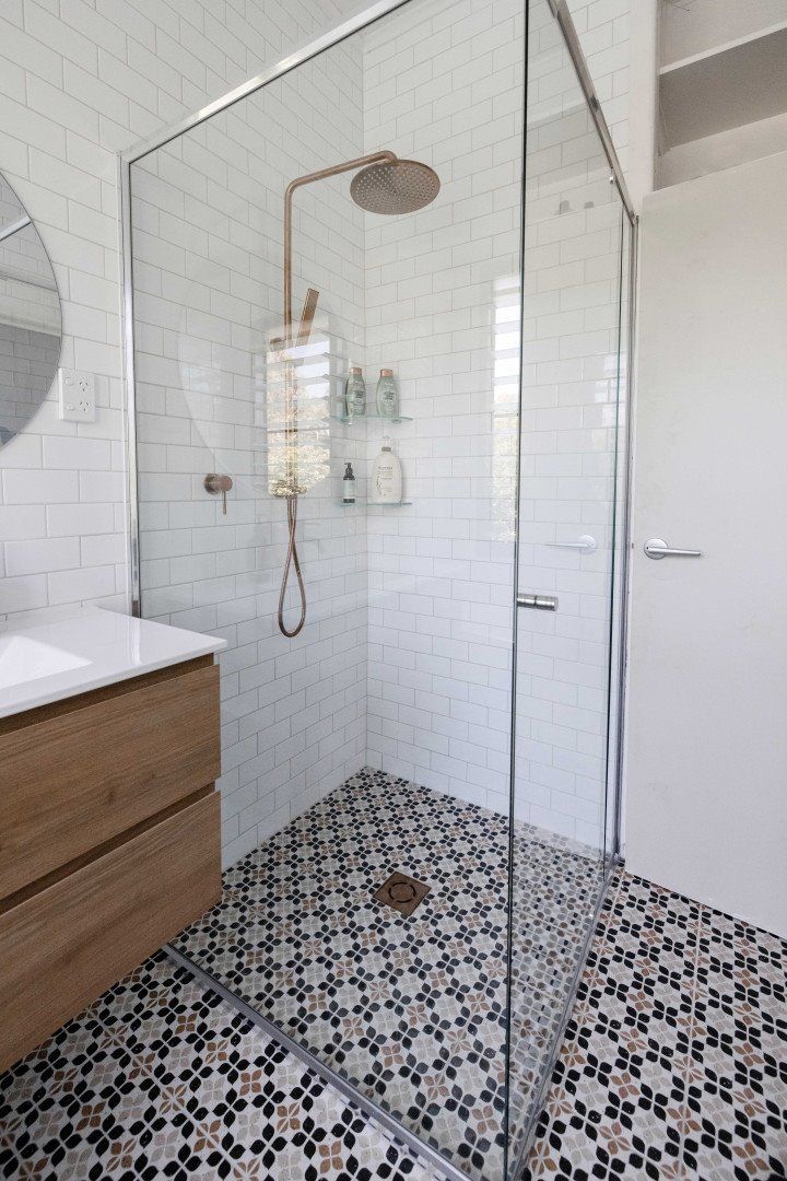 A Bathroom With a Walk in Shower, Sink and Mirror — Anderson Tiling and Waterproofing in Whitfield, QLD