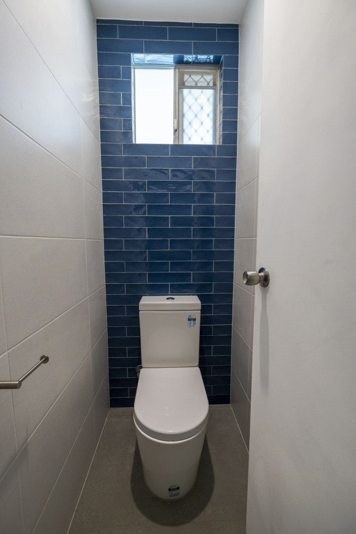 A Small Bathroom With a Toilet and a Window — Anderson Tiling and Waterproofing in Whitfield, QLD