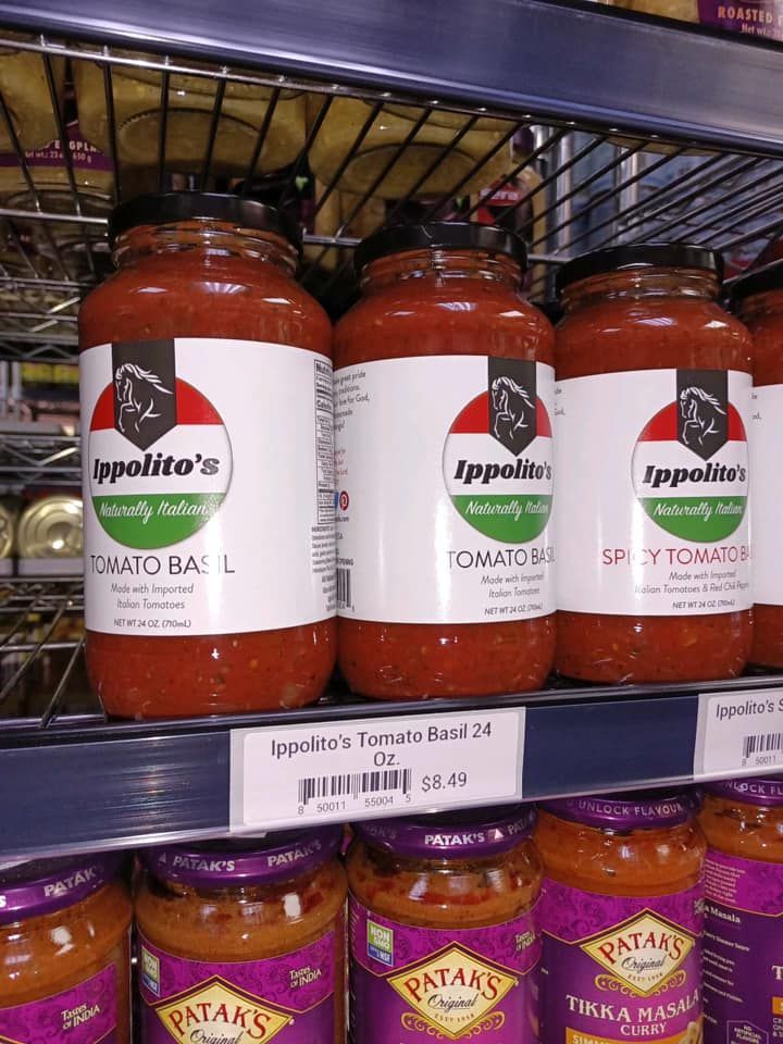 A shelf filled with jars of tomato sauce in a store.