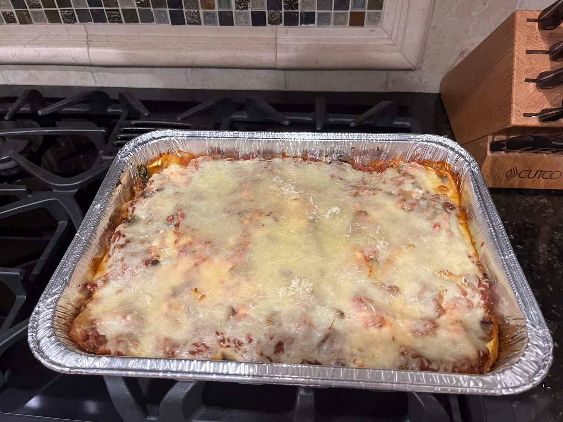 A pan of lasagna is sitting on top of a stove.