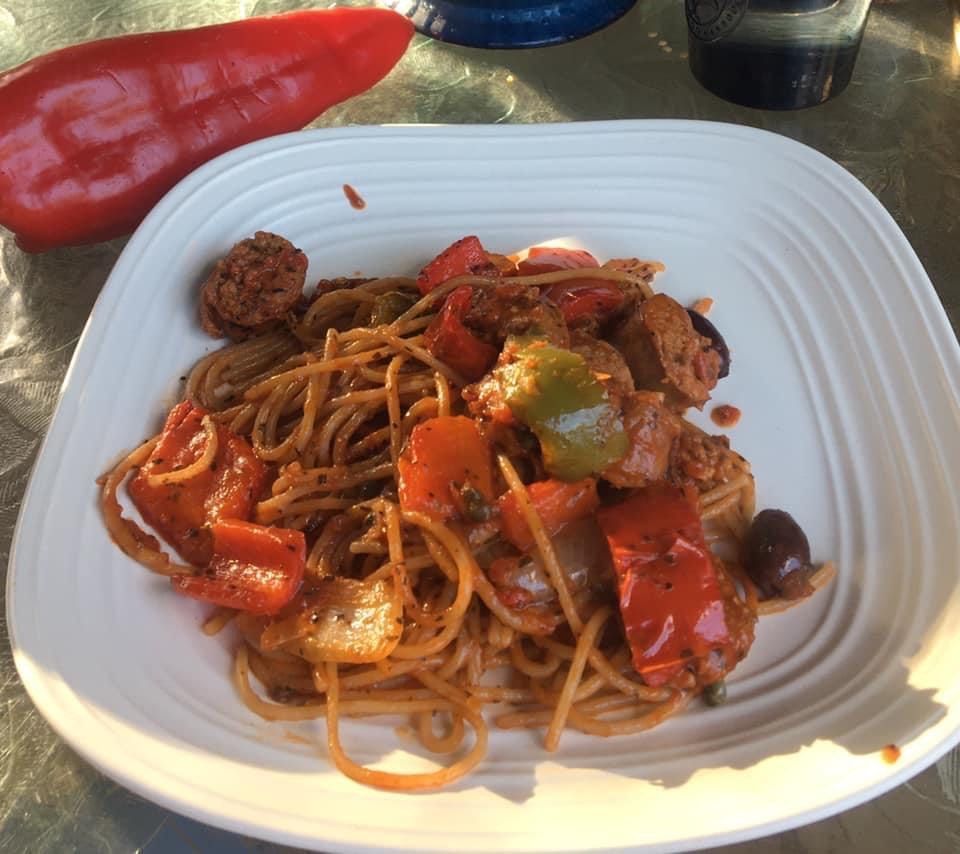 A white plate topped with spaghetti and vegetables