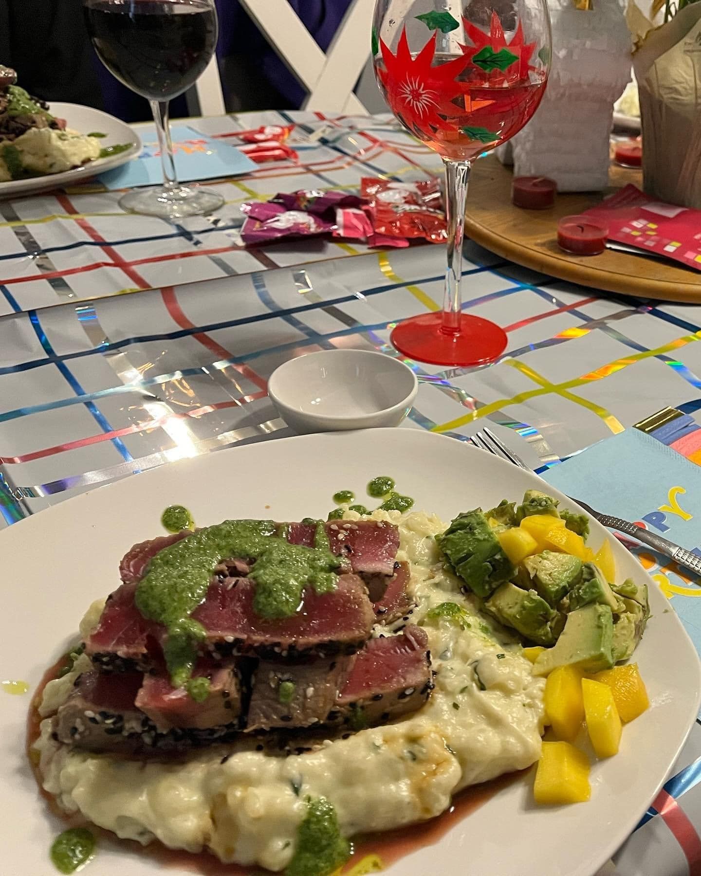 A plate of food with mashed potatoes and meat on a table with wine glasses.