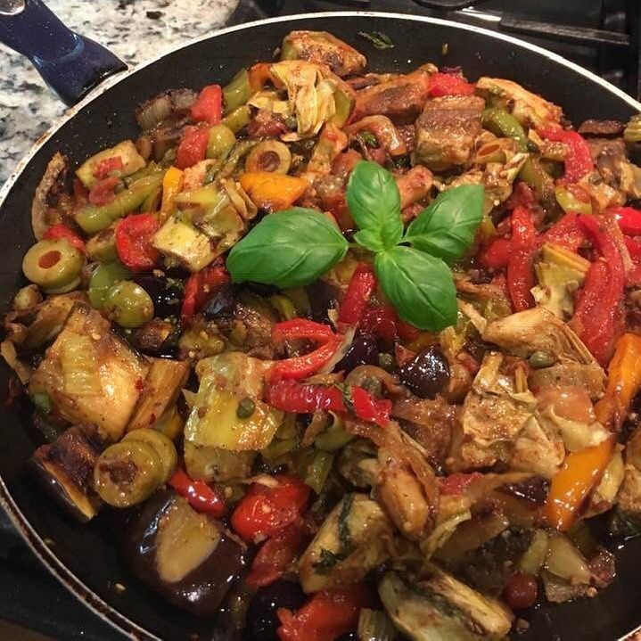 A pan filled with a variety of vegetables and meat