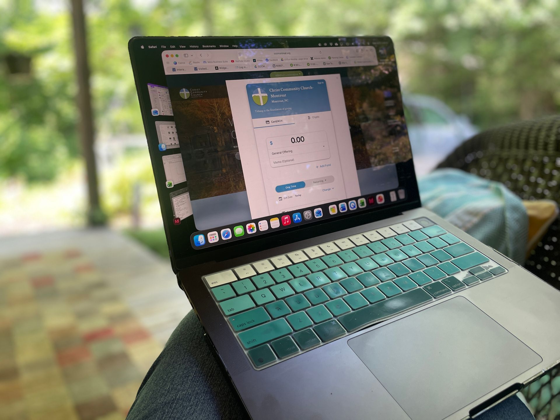 Laptop opened to a giving form with trees in the background.